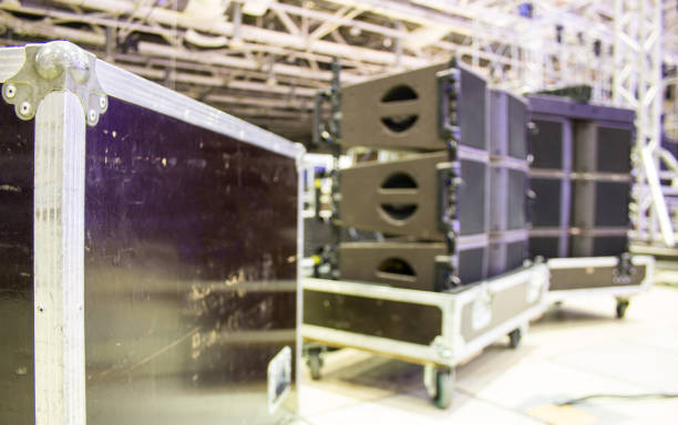 Blurred background of flight case with line array speakers. Installation of professional concert sound equipment with bokeh effect.